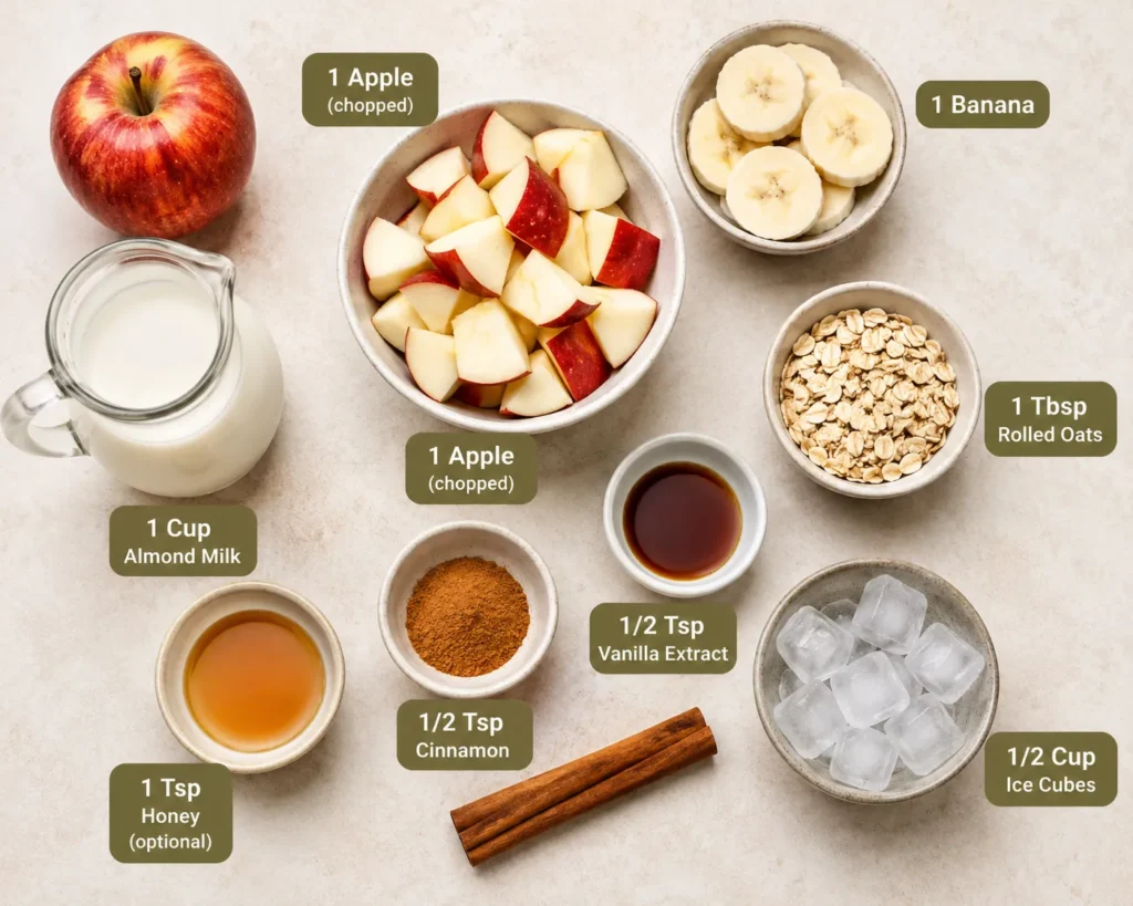 Apple Cinnamon Smoothie ingredients including apple, banana, oats, cinnamon, almond milk, honey, vanilla extract, and ice cubes.