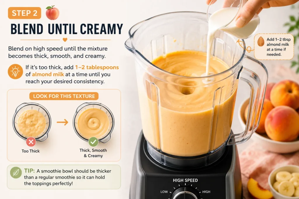 Blending a peach smoothie bowl until thick, smooth, and creamy in a high-speed blender with almond milk added for the perfect consistency.
